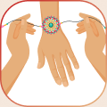 Hands tying a Rakhi